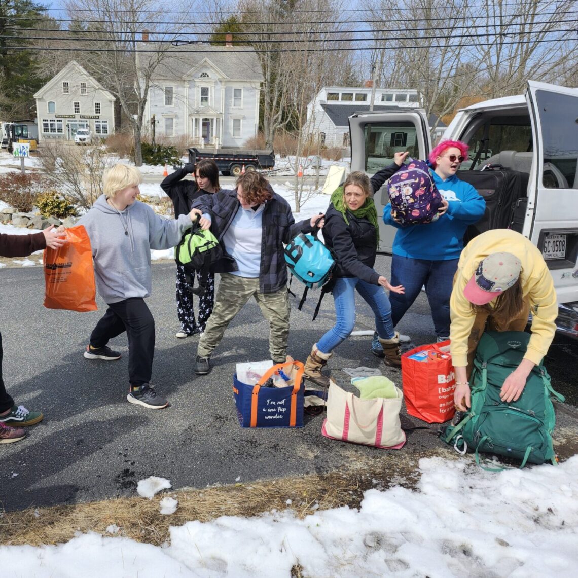 Students and staff load a van in very staged photo.
