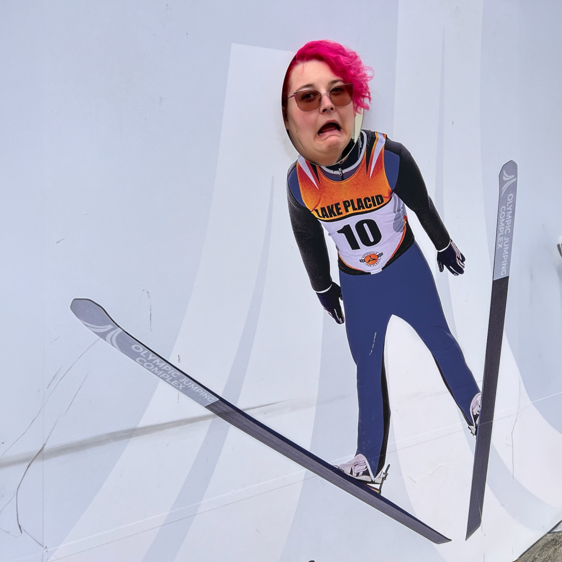 Indigo at a photo site where her face, panicking, is shown on an image of an Olympic ski jump athlete, mid-jump.