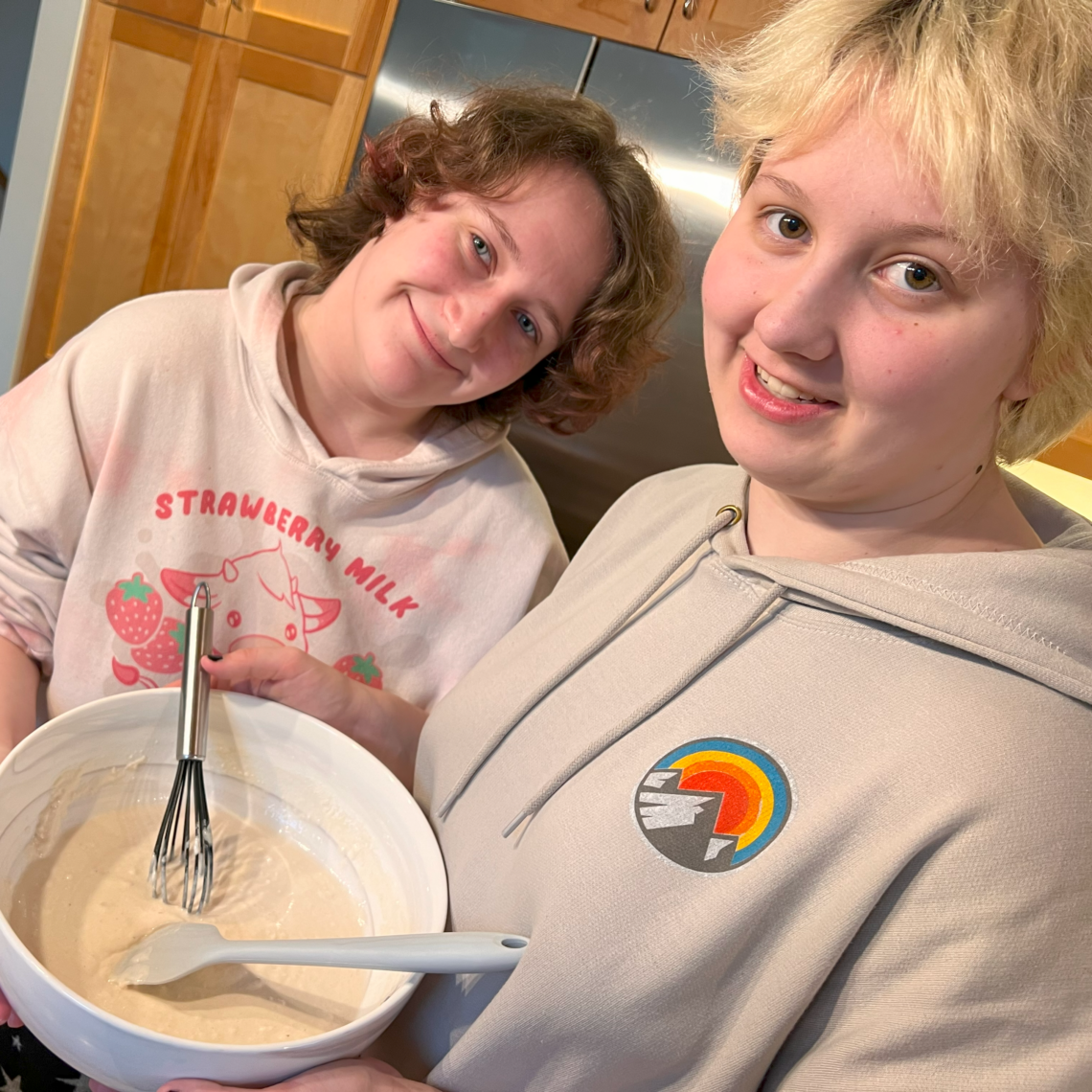 Rex and Kira in tje kitchen, holding a bowl of pancake batter.