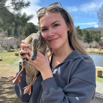Ellie (right) with duck, on a farm.