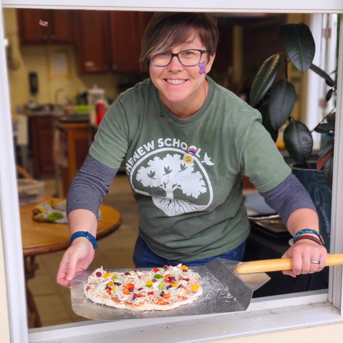 MaryBeth sends a prepped pizza from our kitchen out to our oven crew.
