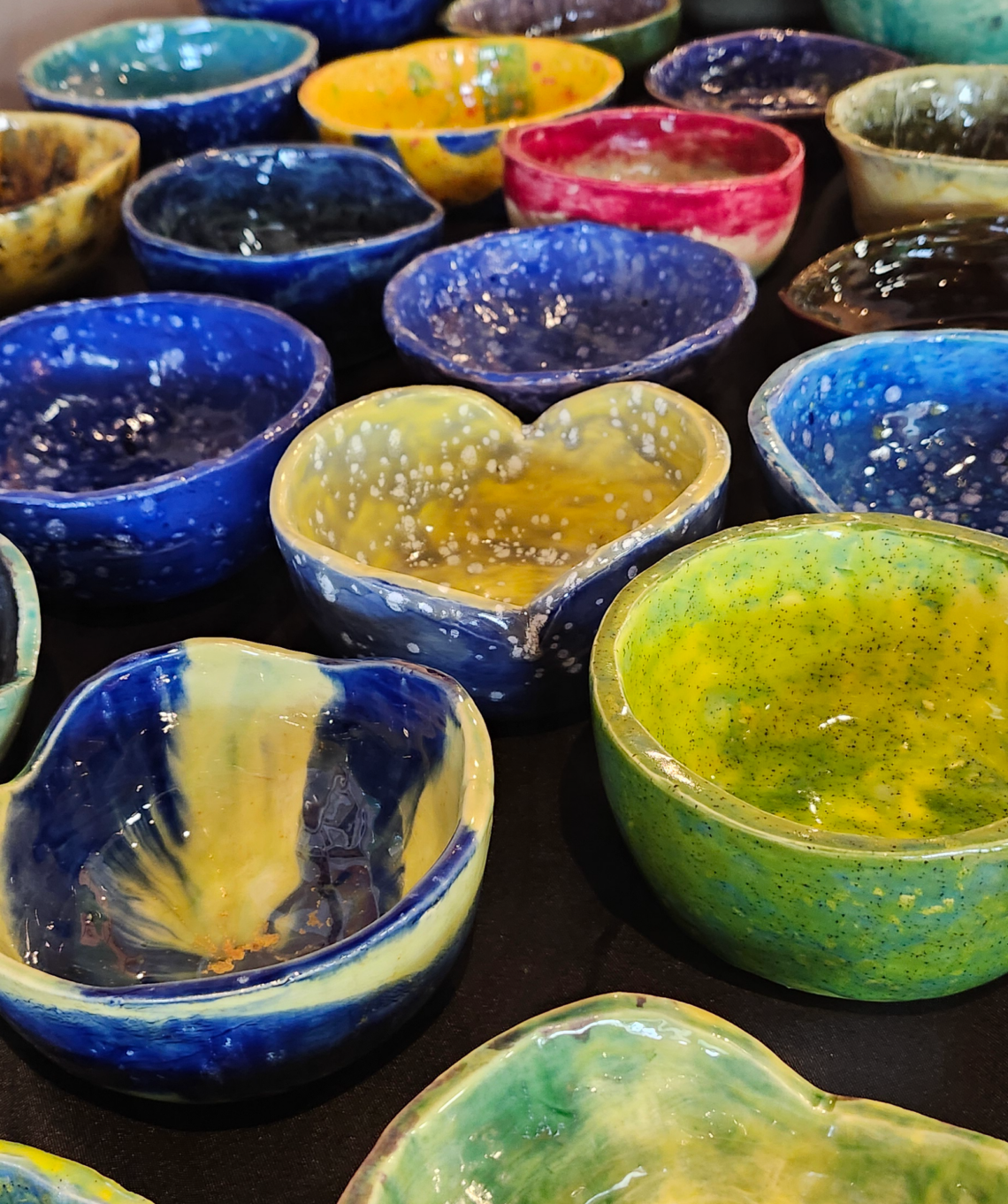 A table covered with colorful ceramic bowls, created by our students.